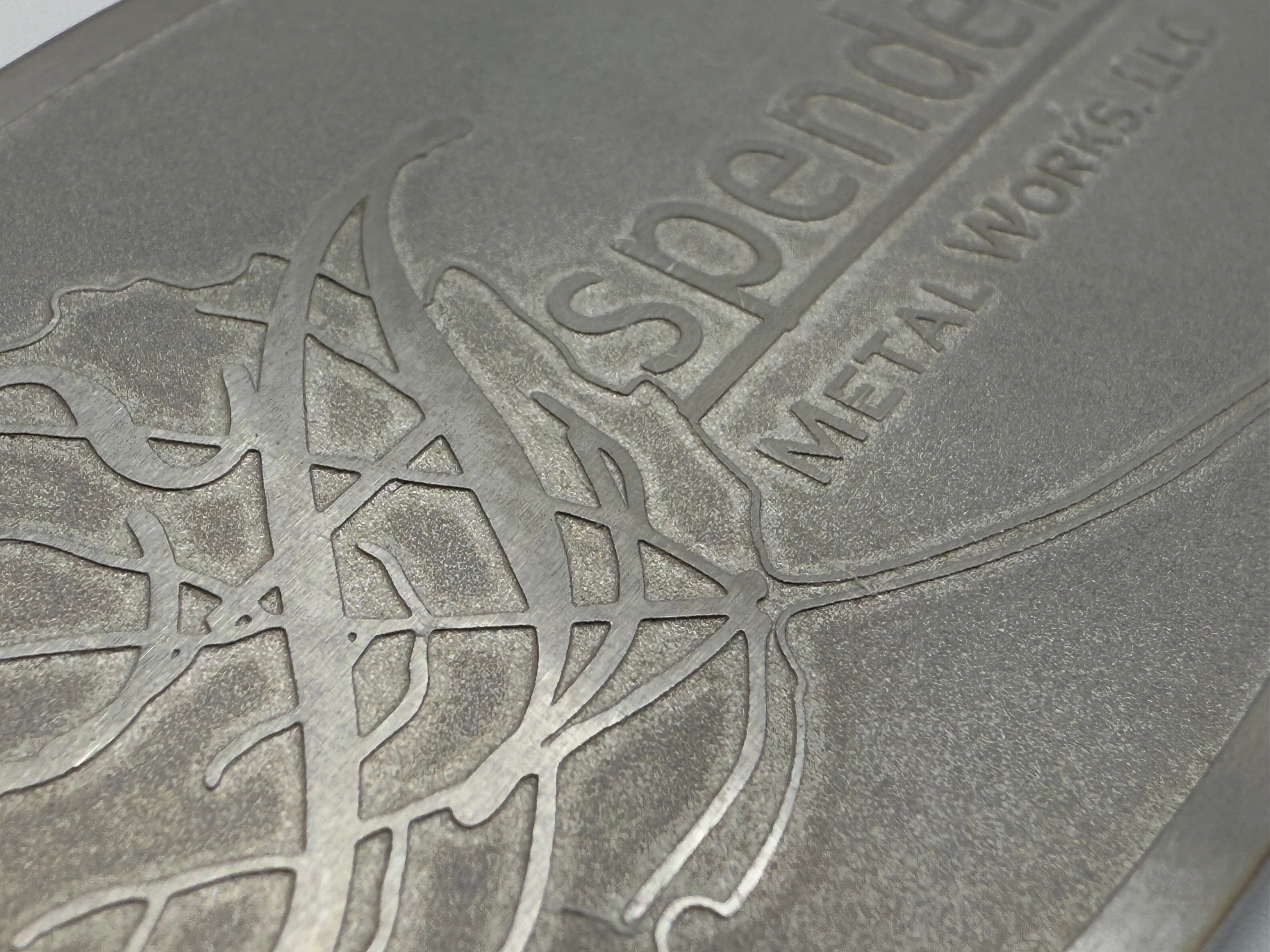 Chemically etched fire pit nameplate with brushed logo and sandblasted recesses.