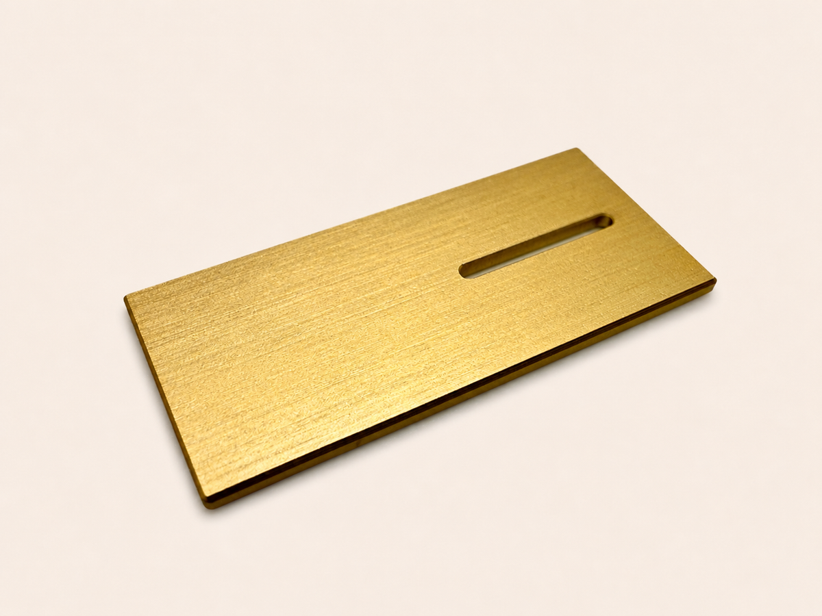 Forged aluminum electronics badge with anodizing and brushing