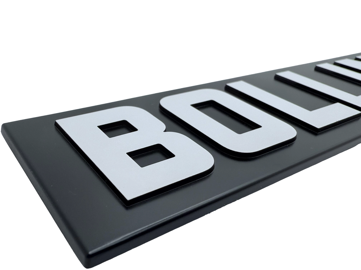 Injection molded badge produced using precision tooling showing molded shape and dimensional consistency