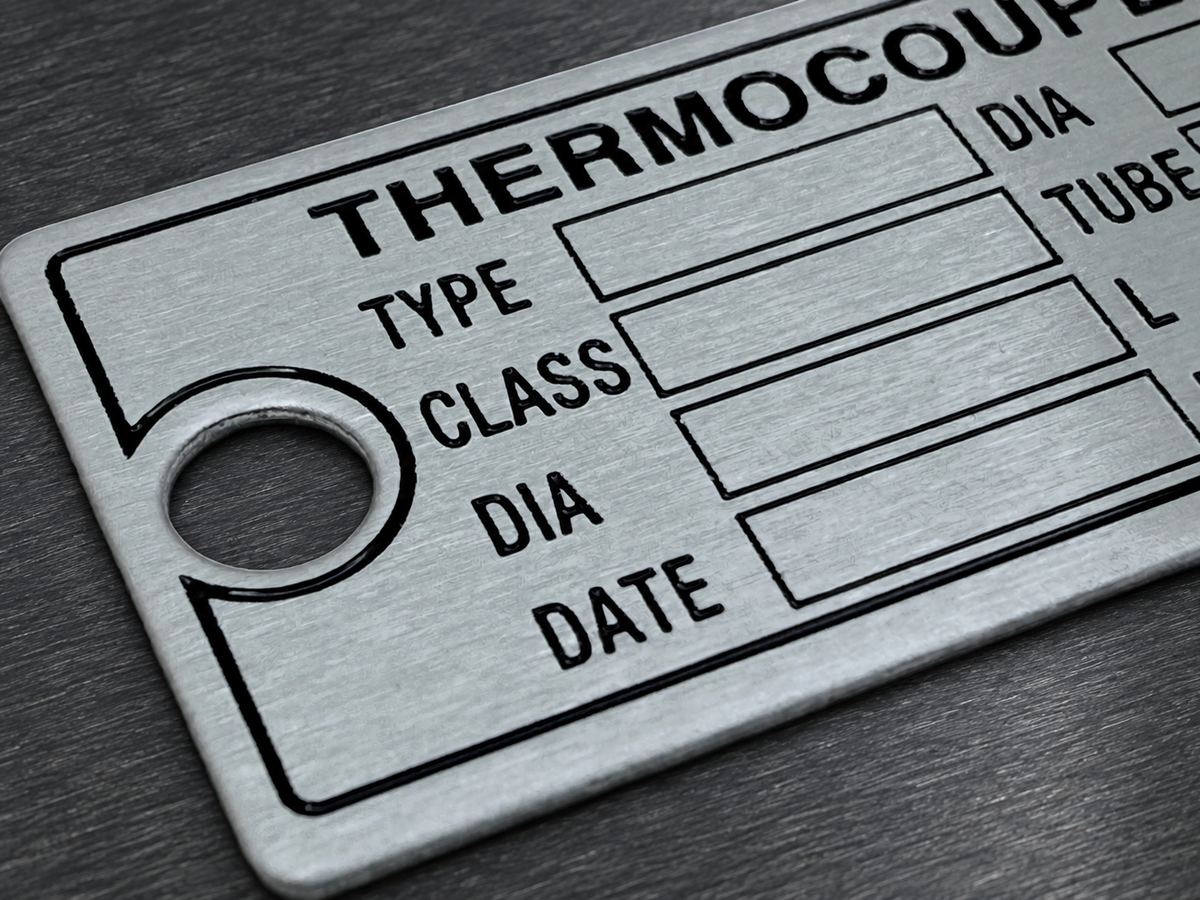 Brushed stainless steel metal tag with printed identification fields and mounting hole