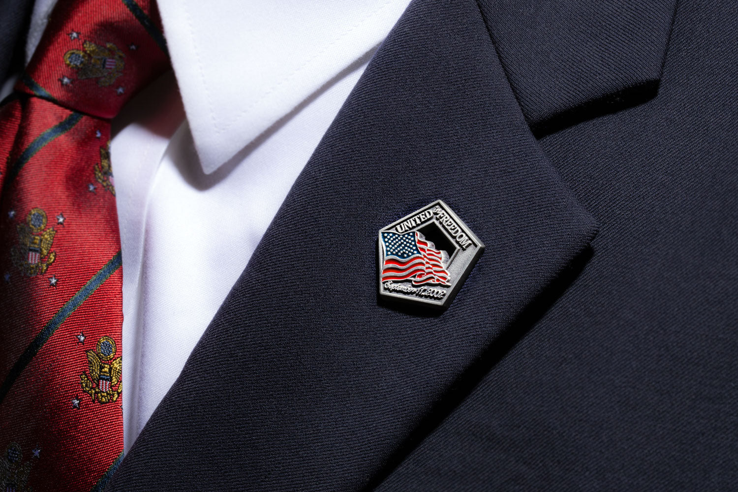 A US flag lapel pin attached to a lapel of a suit