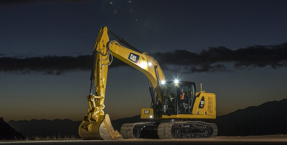 A large CAT excavator displaying it brand with emblems under the moonlight