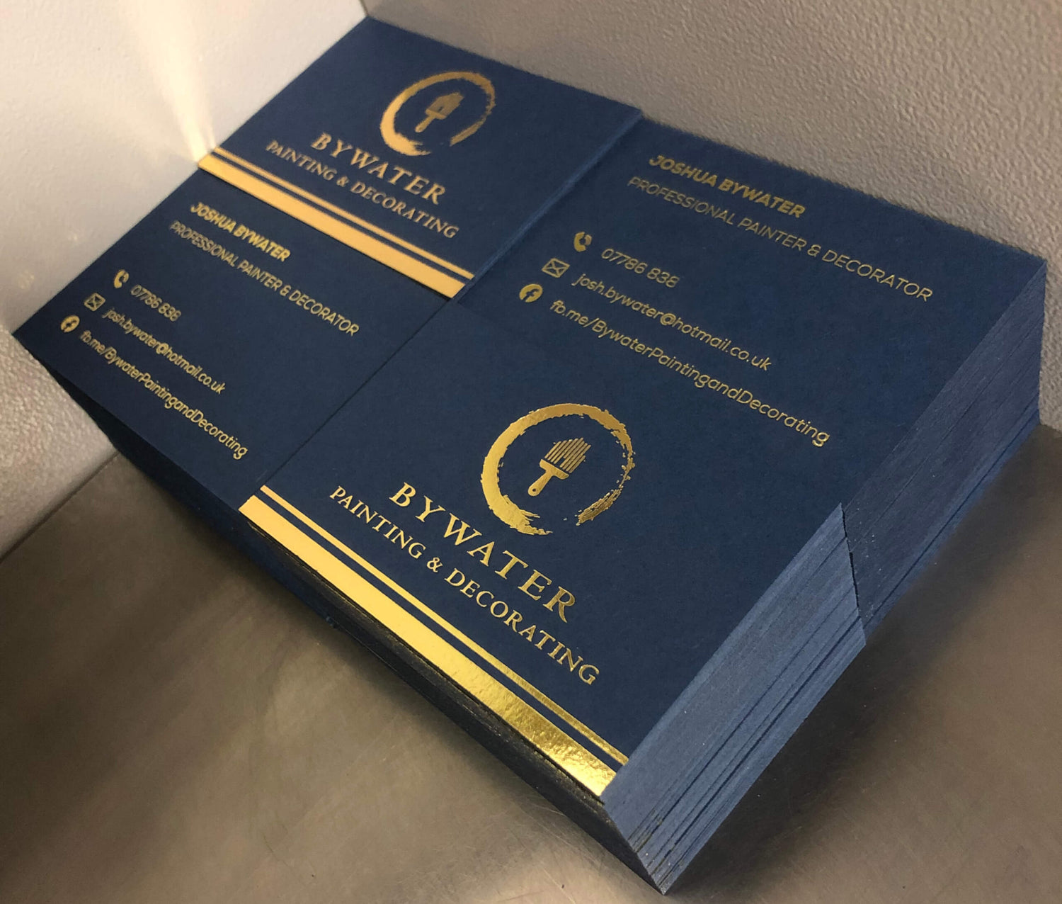 4 stacks of black business cards with gold foil print 