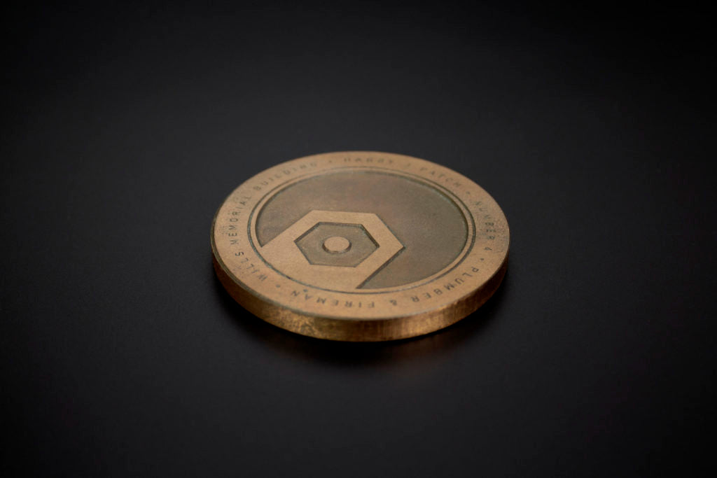 Furniture badge made from brass with an etched surface