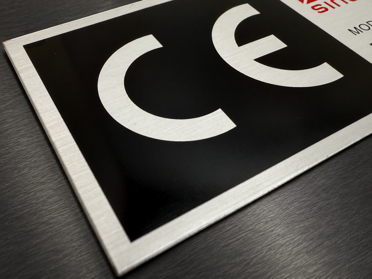 Brushed metal industrial nameplate with black printed graphics and lettering