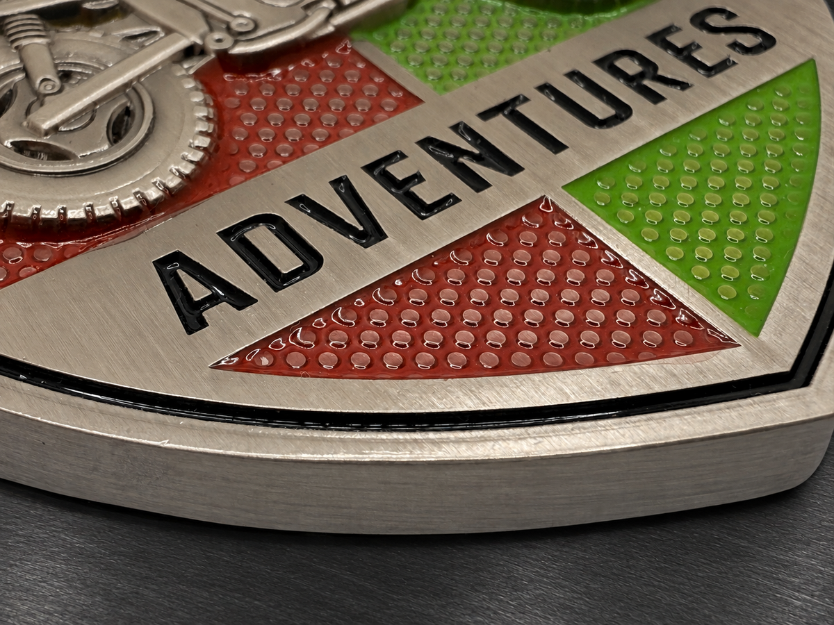 Close-up of a thick metal badge showing material thickness, layered construction, and raised detailing.