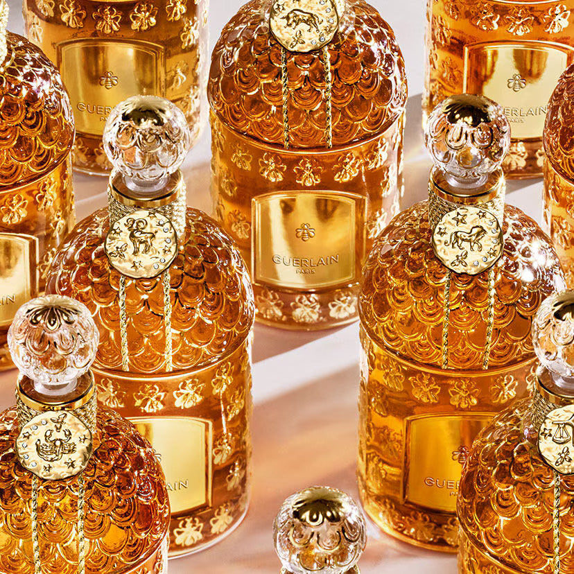 Medallions suspended from the neck of perfume bottles