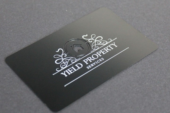 Business card made from titanium with a partially cut out surface and partially printed