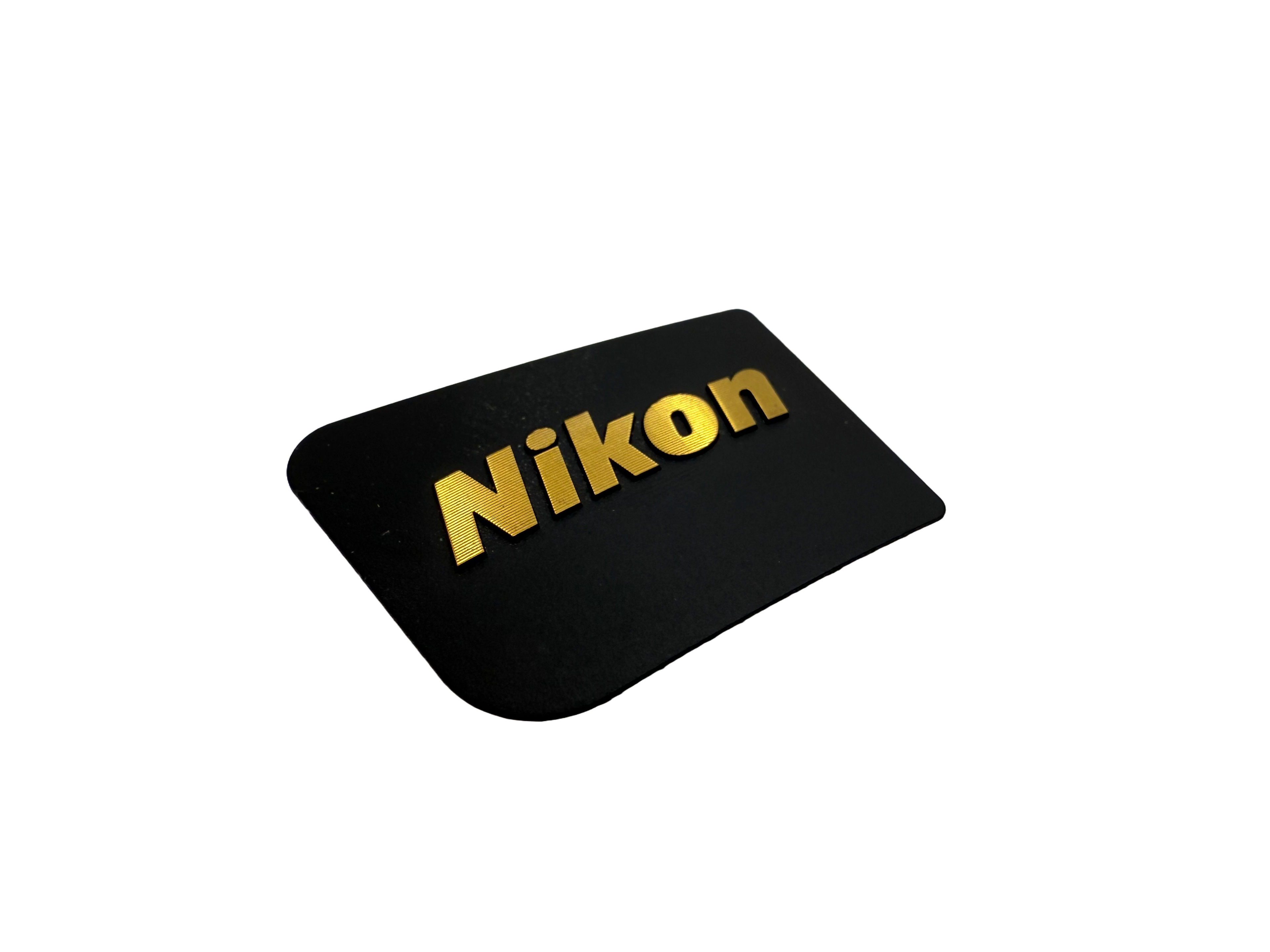 Nikon badge produced using nickel electroforming with diamond cut finish