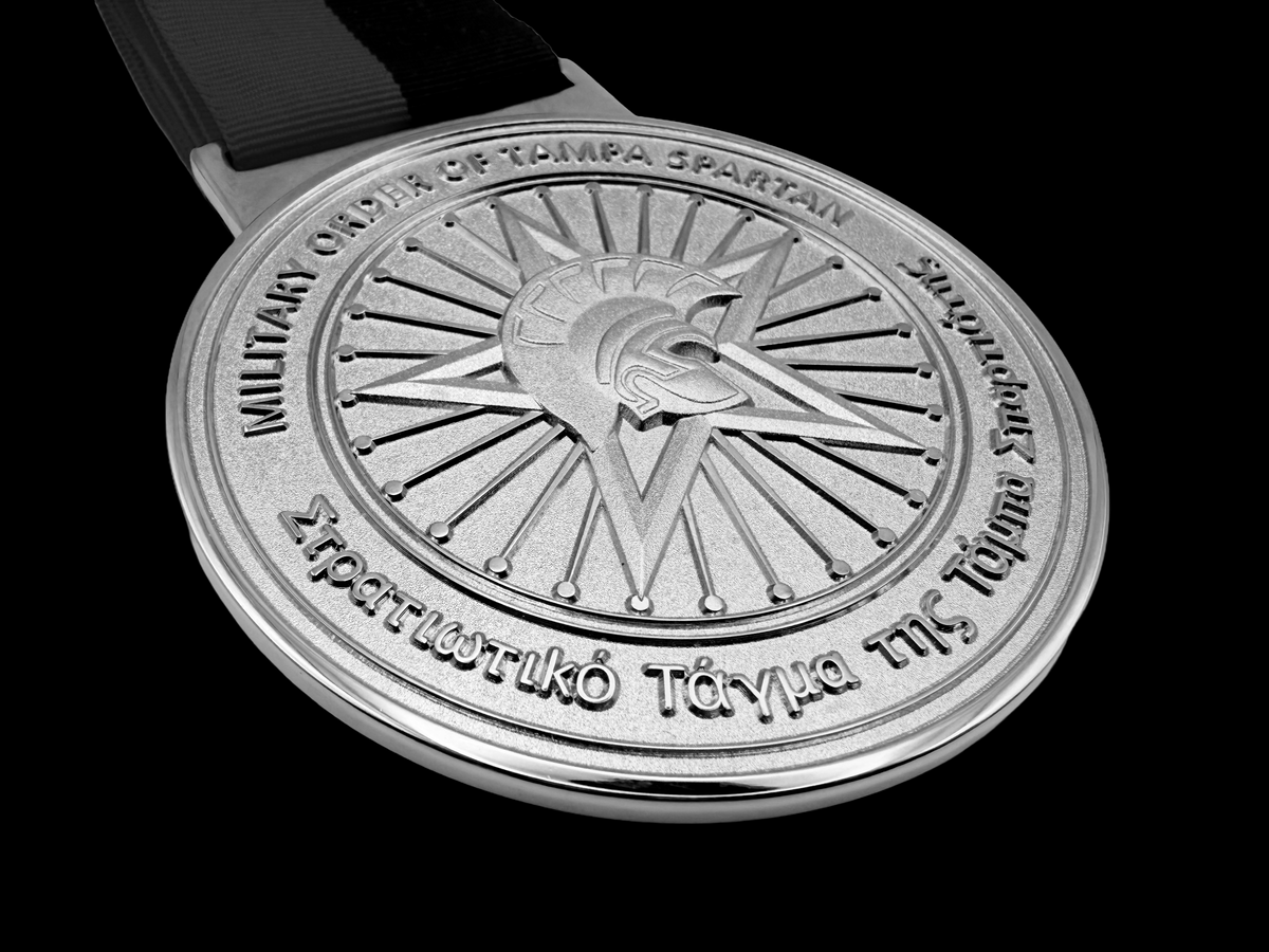 Die struck brass medallion for the University of Tampa with multi-level embossing, sandblasting and polished nickel plating. 