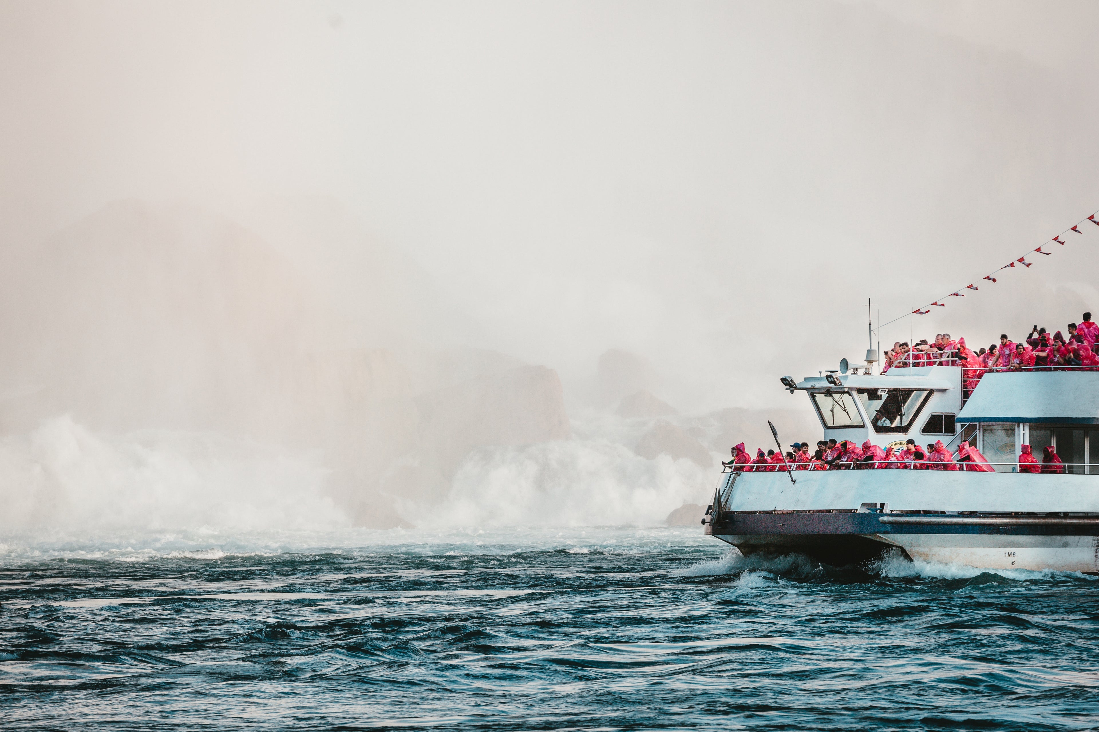 Boat out on the ocean with its crew. Prominent branding on the side of the boat.